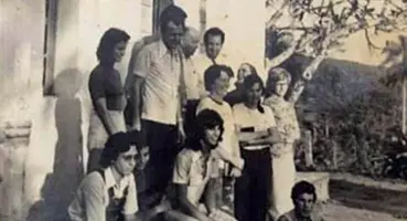 Foto em preto e branco de um grupo de jovens e adultos (cerca de 10 pessoas) posando de forma casual em frente ao Templo de Morrinho